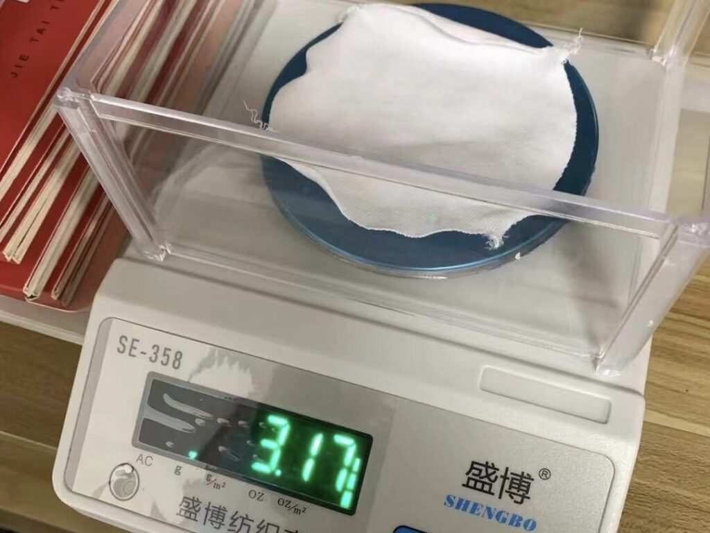 Testing 320gsm heavyweight cotton t-shirt wholesale China fabric on digital scale for high quality apparel sourcing