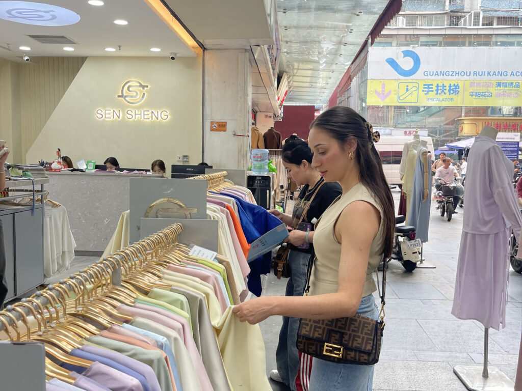 V7proX local guide navigating the complex Guangzhou fabric market during a client's China business trip for custom design
